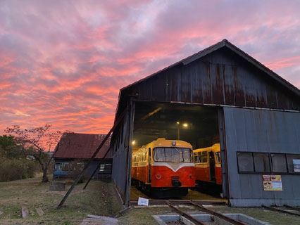 夕暮れ時の機関庫とレールバス